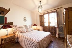 um quarto com uma cama com um edredão listrado e uma janela em Halo - Typical Spanish Downtown House Close To The Sea em Marbella