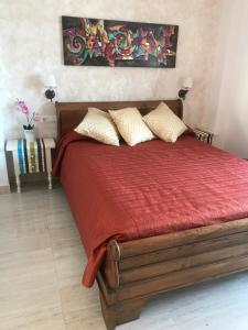 a bedroom with a bed with red sheets and pillows at PLAZA DE ESPAÑA 1 DORMITORIO in Nerja