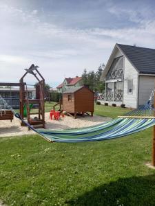 hamak w ogrodzie z domem w obiekcie Domki w Rusinowie blisko morza w mieście Jarosławiec