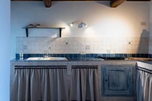 una cucina con lavandino e piano cottura di Acqua di Civita Beauty & Rooms in Mercatello a Bagnoregio