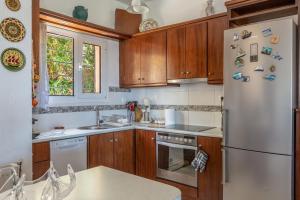 a kitchen with wooden cabinets and a white refrigerator at BIG BLUE in Rafina