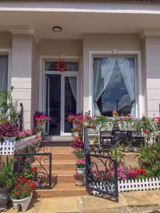 a porch with flowers and a table and chairs at Jolie House in Da Lat