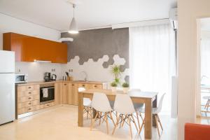 a kitchen with a wooden table and white chairs at Cozy Apartment in Central Athens - Sleeps 5 in Athens