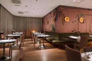 a restaurant dining room with tables and chairs at Aemilia Hotel Bologna in Bologna