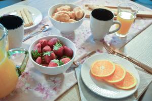 una mesa con platos de fresas, naranjas y bebidas en VAMA APARTMENT, en Plataniás