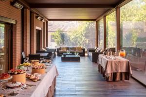 ボローニャにあるSavhotel Aemilia Bolognaの建物内のパティオ(テーブル、椅子付)