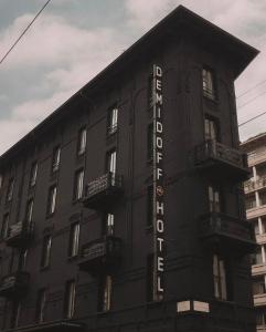 a black building with a sign on the side of it at Demidoff Hotel Milano in Milan