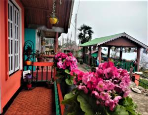 budynek z różowymi kwiatami na płocie w obiekcie Temi Sarika Homestay w mieście Damthang