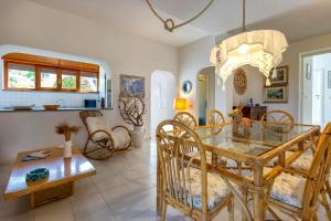 a dining room and living room with a glass table at Villa Stintino in Stintino