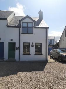 een wit huis met een auto ervoor geparkeerd bij Anchor, Dunfanaghy in Dunfanaghy