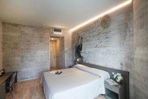 a bedroom with a white bed and a brick wall at Sole Mare in Ventimiglia