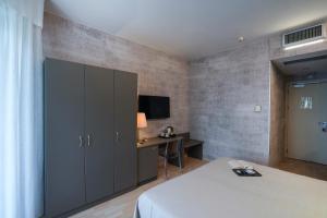 a bedroom with a bed and a desk and a tv at Sole Mare in Ventimiglia