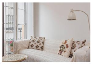 uma sala de estar com um sofá branco com almofadas em Cosy Alfama em Lisboa