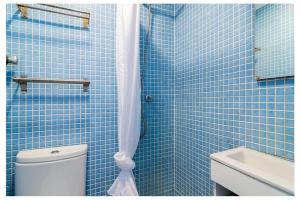 リスボンにあるCosy Alfamaの青いタイル張りのバスルーム(トイレ、シンク付)