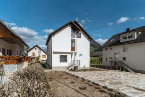 a white house with a black roof at Julian Manor apartments in Bovec