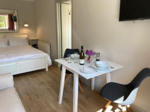 ein Zimmer mit einem weißen Tisch und Stühlen und einem Bett in der Unterkunft Far Hill Studio in Wyck Rissington