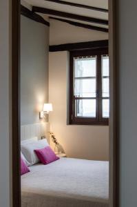 a bedroom with a bed and a window at Agroturismo Montefrío in Urnieta