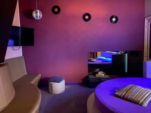 Habitación púrpura con cama y sofá en Le Vénitien en Lieja