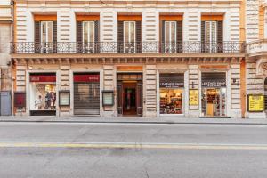 una facciata di un edificio con negozi su una strada di Tritone Minimal a Roma