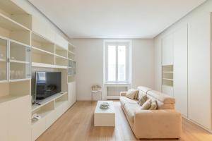 un soggiorno con un divano e una TV di Tritone Minimal a Roma