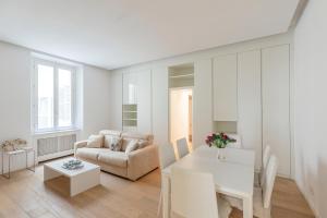 un soggiorno bianco con tavolo e divano di Tritone Minimal a Roma