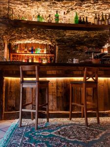 twee houten stoelen aan een bar in een kamer bij Visaisa taverna & foresteria in Acceglio