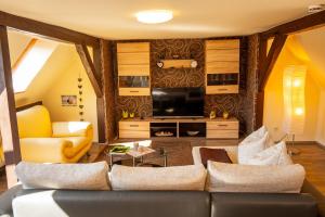 ein Wohnzimmer mit einem Sofa und einem TV in der Unterkunft Ferienhaus An der Postmeilensäule in Lübbenau