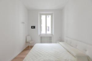 una stanza bianca con un letto e una finestra di Tritone Minimal a Roma