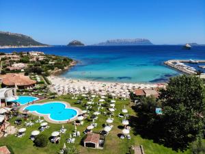 una vista aerea su una spiaggia con ombrelloni e sull'oceano di Baia Caddinas Clubresidence a Golfo Aranci