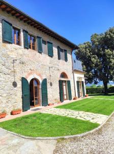 a large stone building with green shutters on it at Giglio Dorato in Castiglion Fiorentino