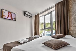 a bedroom with a bed and a large window at Hotel Elit in Sandanski