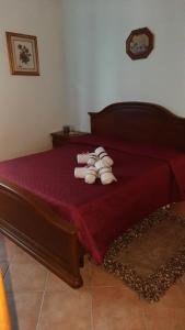 ein Bett mit roter Bettwäsche und weißen Handtüchern darauf in der Unterkunft Appartamento Giulia in Nizza Monferrato