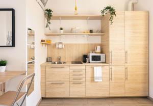 een keuken met houten kasten en een magnetron bij A Yellow Touch - Modern Studio in Isola Milano in Milaan