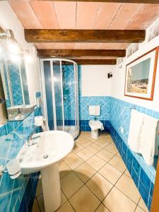 W wyłożonej niebieskimi kafelkami łazience znajduje się umywalka i toaleta. w obiekcie Rocca&Torre Houses w Cefalù