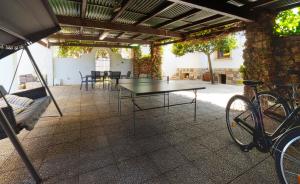 a patio with a table and chairs and a bike at Casa Sa Posidonia -POSIDONIA SURF & STAY- in Ciutadella