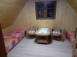 um quarto com duas camas e uma mesa e cadeiras em Domek Letniskowy - M & E em Warchały