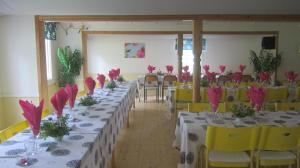a room with tables and chairs with pink flowers on them at Sikhall Camping in Sörbo
