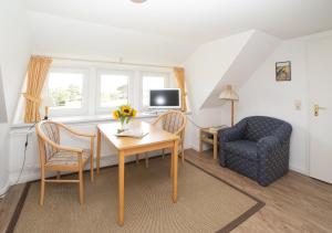 ein Wohnzimmer mit einem Tisch und einem Stuhl in der Unterkunft Haus Bräätlun Ferienwohnung Bräätlun 2 in Norddorf
