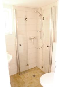 un baño con ducha y lavabo en Haus Anneliese Bungalow Düne, en Norddorf