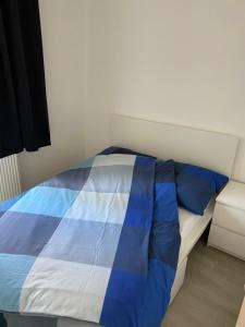 a blue and white bed in a room at Zentrale und schöne Ferienwohnung in Lübeck