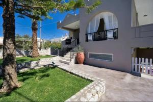 una casa con un árbol y una valla blanca en Casa Regno, en Ayiá