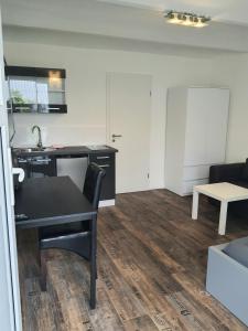 ein Wohnzimmer mit einem Tisch und einer Küche in der Unterkunft Westerwald Apartments in Straßenhaus