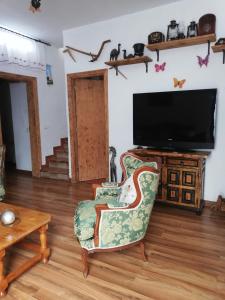 sala de estar con silla y TV en Casa Osciris, en El Cercado