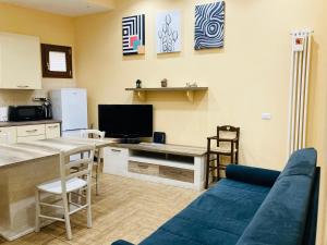 Villino Marcella في روما: غرفة معيشة مع أريكة زرقاء ومطبخ