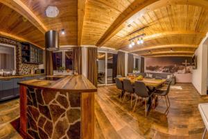 a kitchen and dining room with a wooden ceiling at Chalet Zuberec in Zuberec