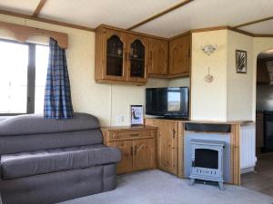 uma sala de estar com lareira e televisão em Lettoch Farm Holiday Home em Dufftown