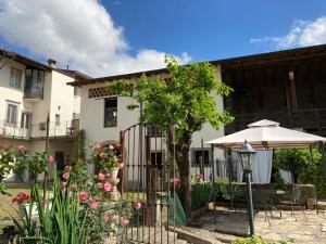 a house with a gate and a table and an umbrella at B&B Corte Seguini in Bagnatica