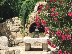 une arche en pierre avec une table ornée de fleurs roses dans l'établissement VILLA MATHIS, à Mouans-Sartoux