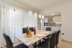 a dining room with a white table and chairs at House Pula 2080 in Pula