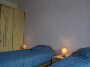 Gîte Montipouret, 3 pièces, 4 personnes - FR-1-591-190 في Montipouret: كان هناك سريرين في غرفة النوم مع ملاءات ومصابيح زرقاء